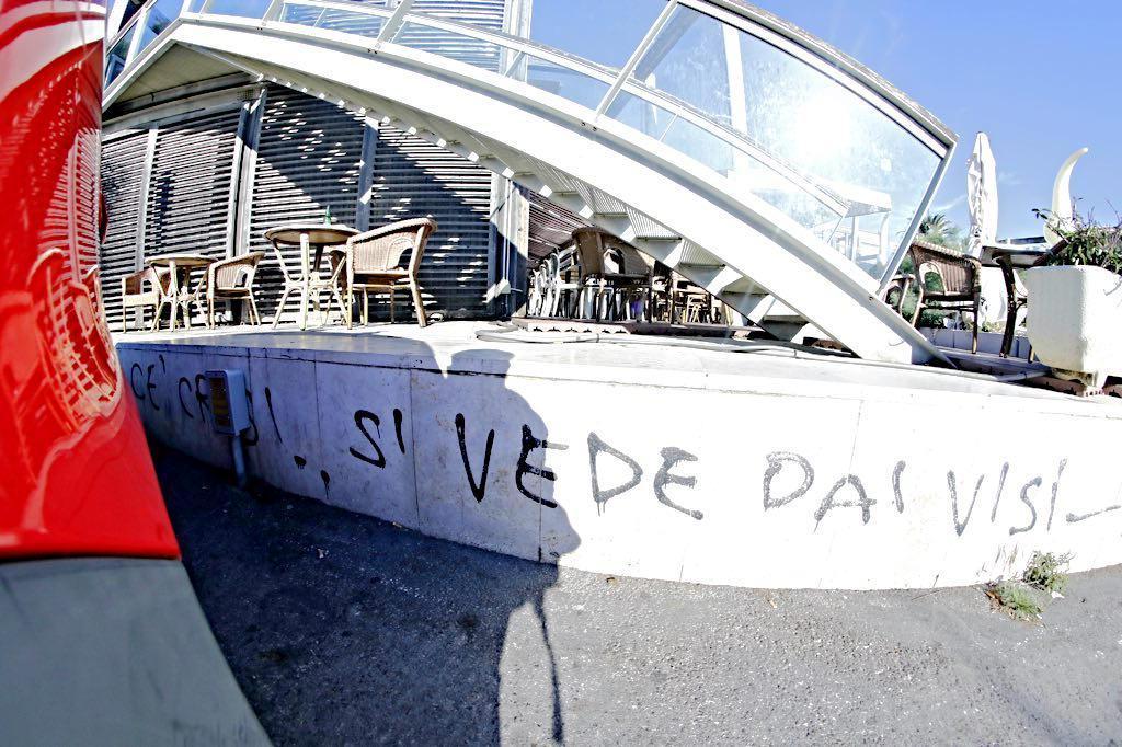 La scritta "c'è crisi, si vede dai visi" che si trova tra il Cantiere e il moletto d'Ardenza (Marzi Pentafoto)