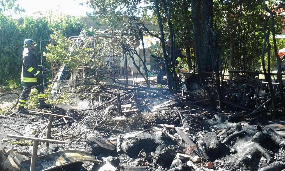 A fuoco una capanna vicino alle case