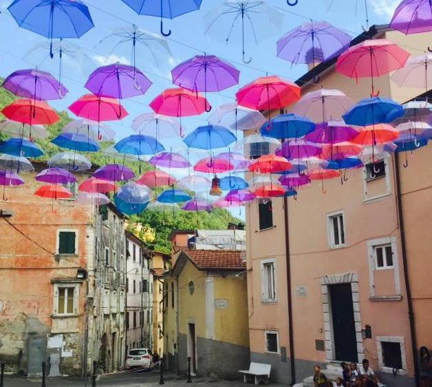  Un tetto colorato in centro con cento ombrelli in cielo 