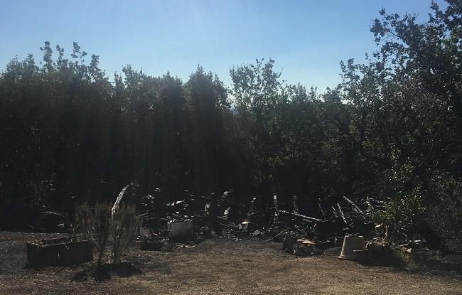 Quello che resta della casa in legno devastata dal fuoco