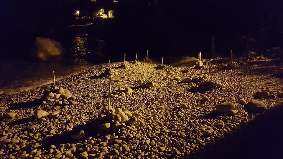 Pali di ombrellone piantati per occupare la spiaggia di notte