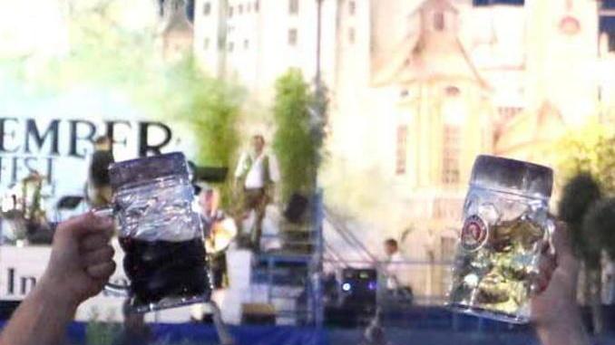 Lancia un boccale in mezzo alla gente alla festa della birra