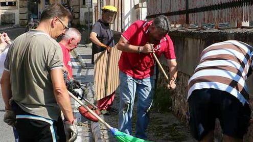 Volontari in azione con ramazze e spugne per ripulire via Prado