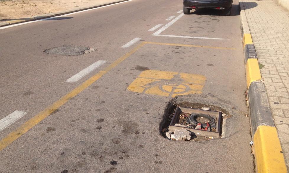 Un parcheggio disabili con voragine
