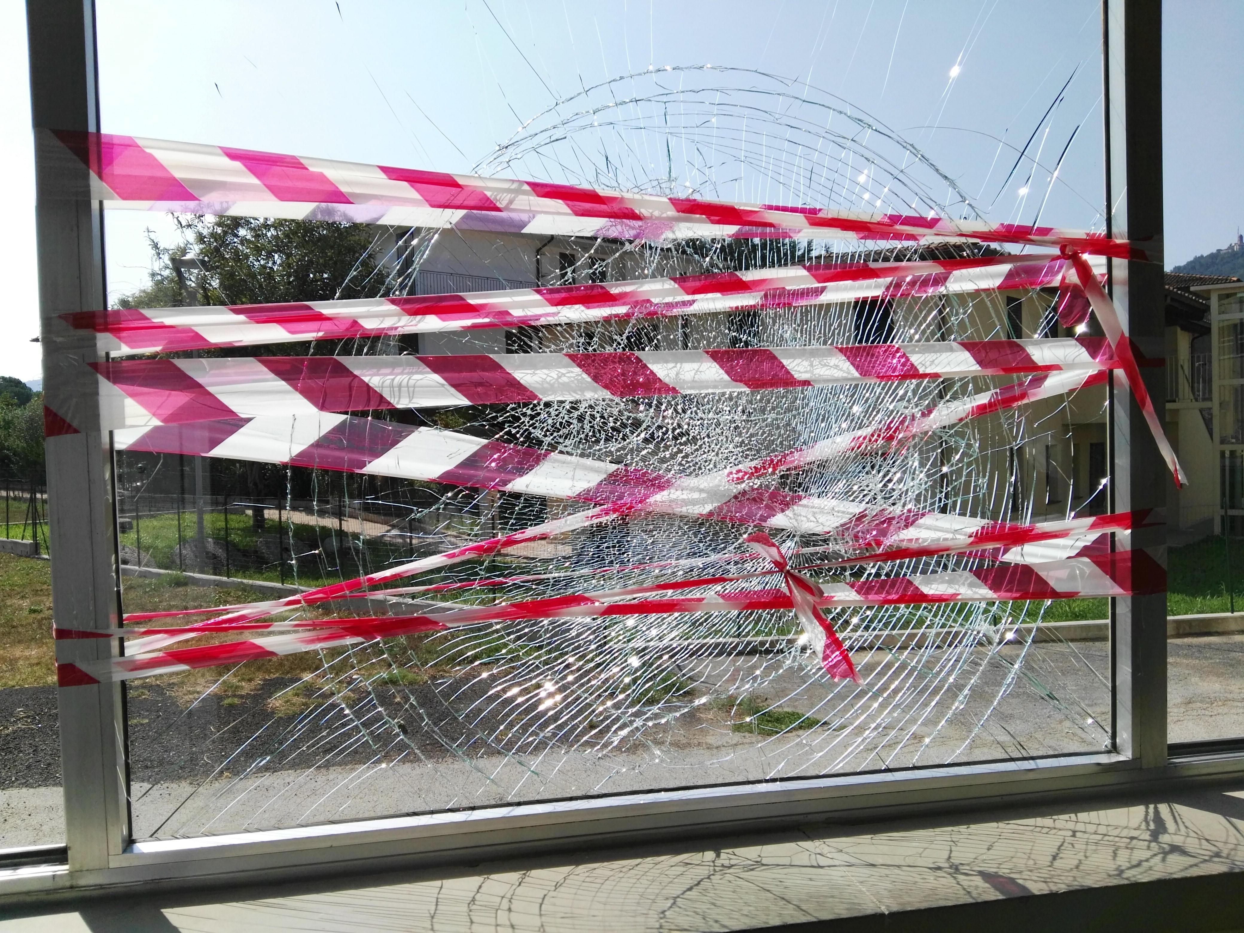 Una vetrata della scuola distrutta dai vandali