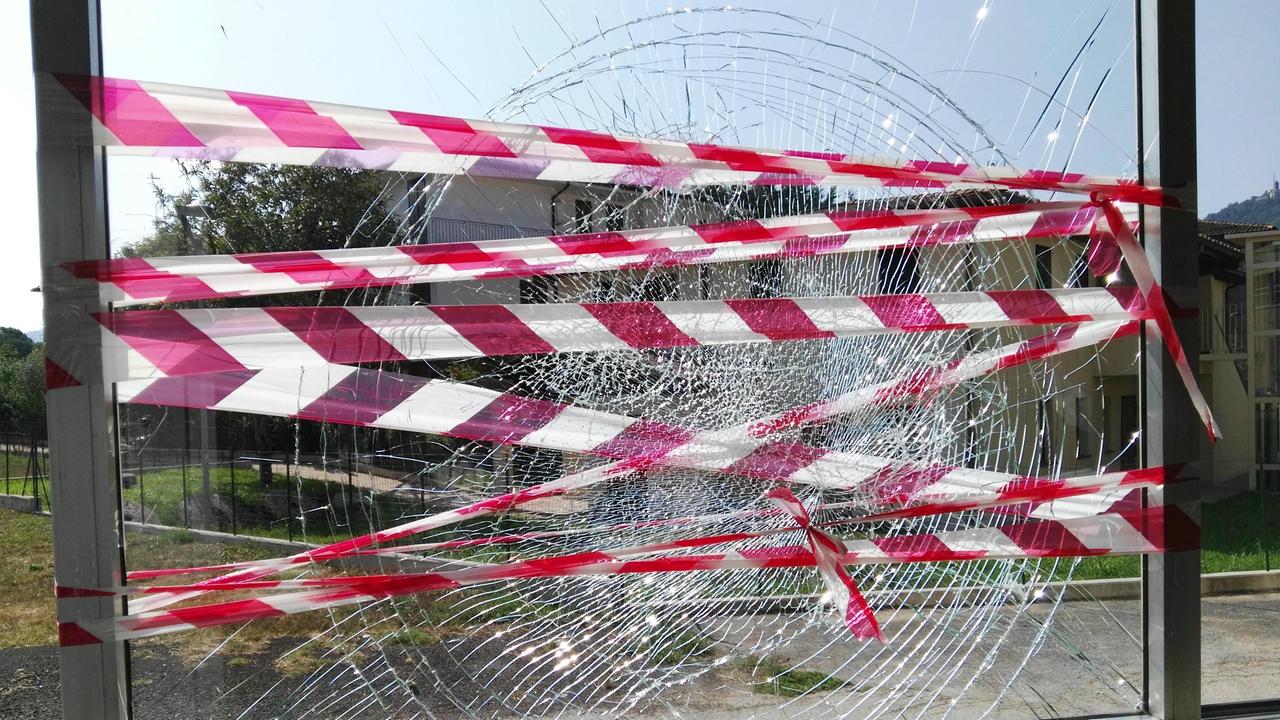 Una vetrata della scuola distrutta dai vandali