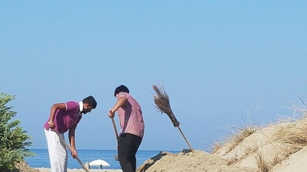I migranti al lavoro per pulire gli arenili