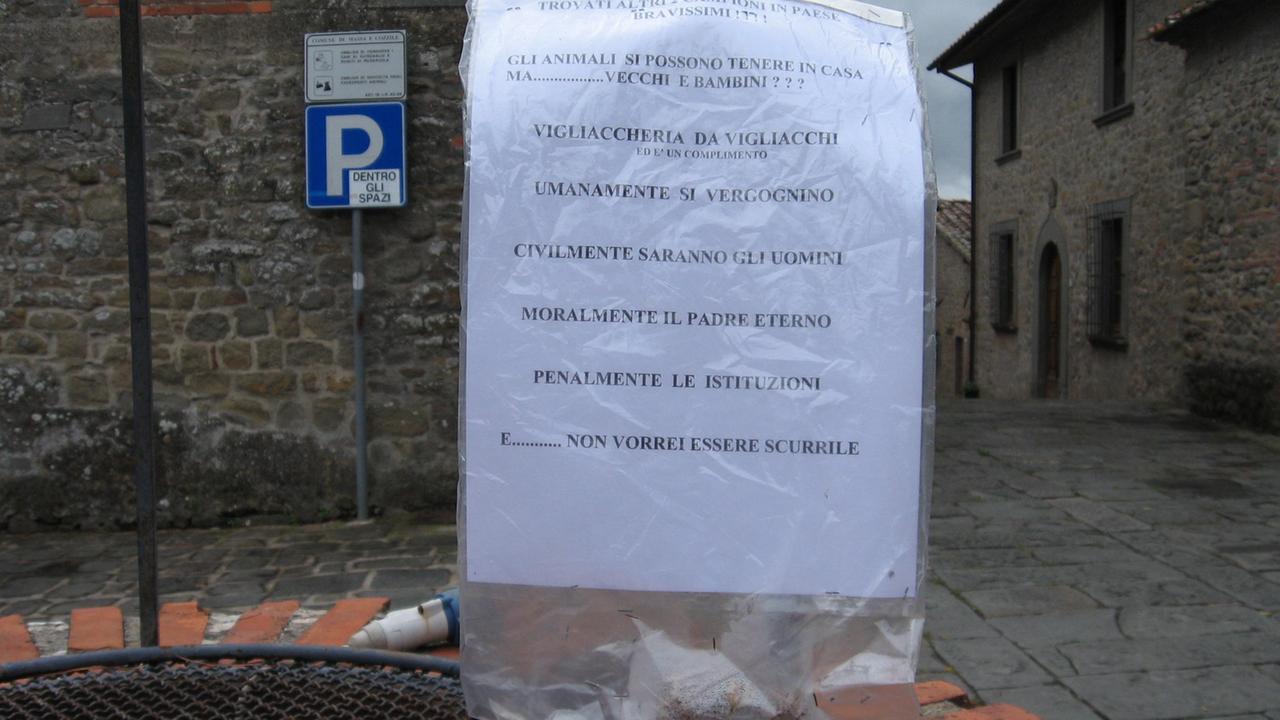 Un cartello affisso a Cozzile rivolto a chi lascia i bocconi avvelenati sull'asfalto