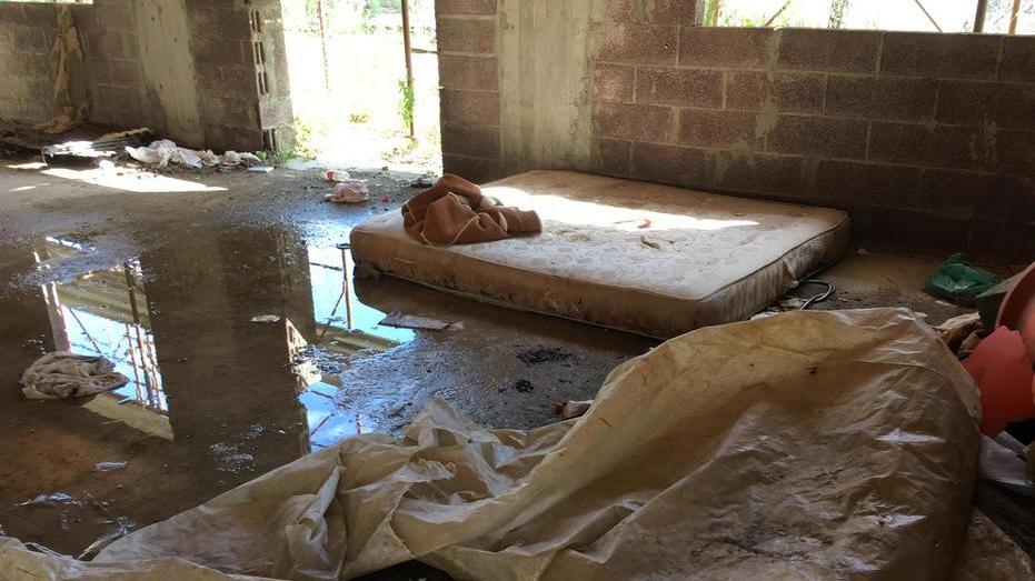 Un "letto" in mezzo ai rifiuti nell'ex palazzo Enel (Foto Franco Silvi)