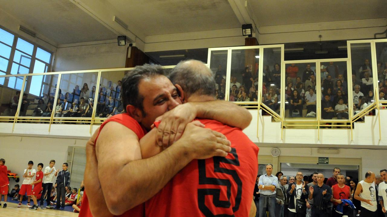 Mario Sanna abbraccia un ex compagno di basket nel palazzetto gremito (foto Massimo Locci)