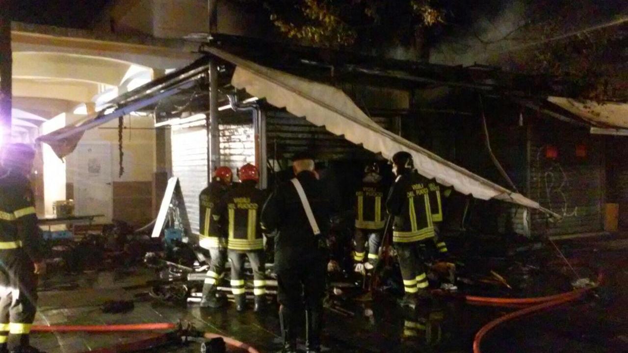 I vigili del fuoco mentre spengono l'incendio al banco del mercato andato a fuoco