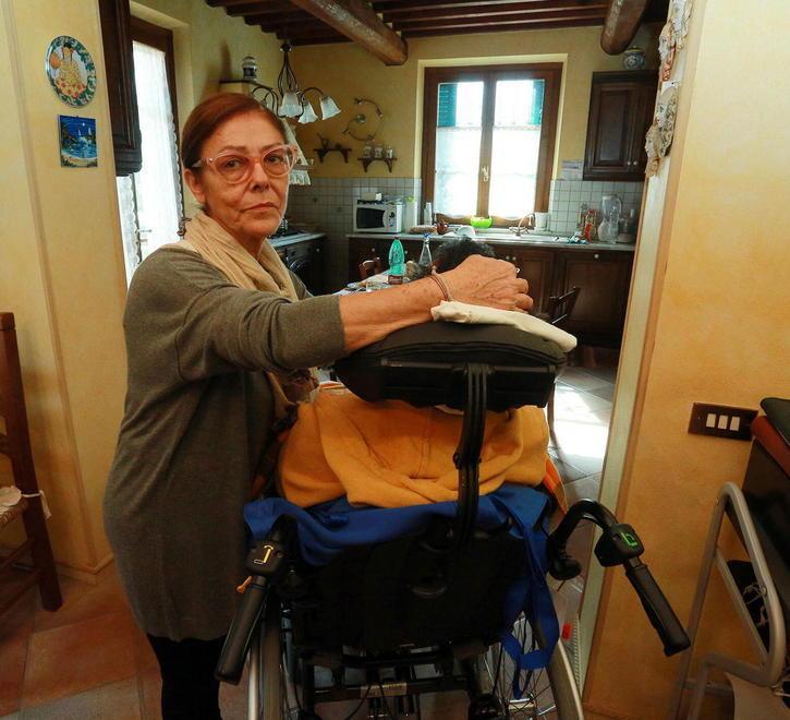 Francesca De Vecchis mentre accudisce il marito in casa (foto agenzia Carlo Sestini)