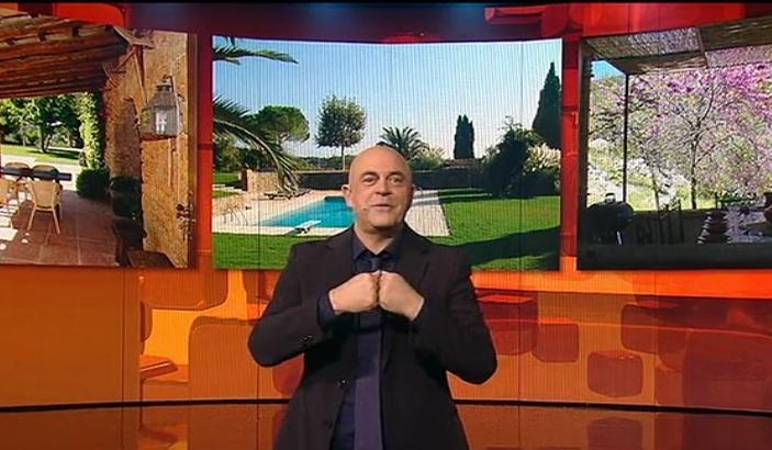 Crozza con alle spalle le foto della sua presunta villa lucchese