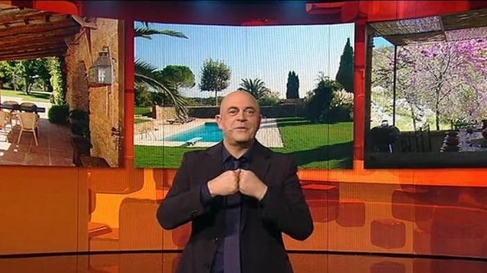 Crozza con alle spalle le foto della sua presunta villa lucchese