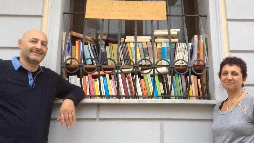 Federica Tamburini con il marito di fronte alla rinata "biblioteca da strada" di via Savi in Darsena