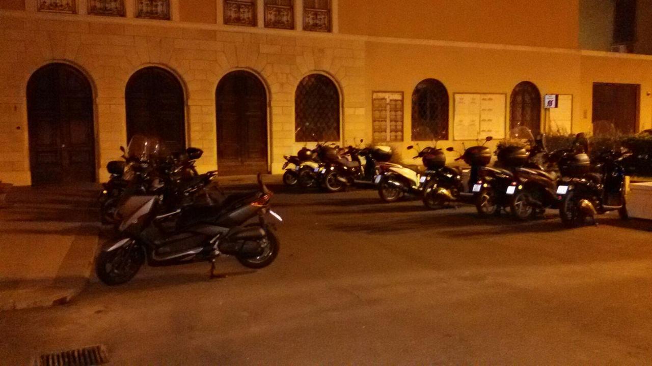 La fila di motorini in sosta "sulla" porta del Comune