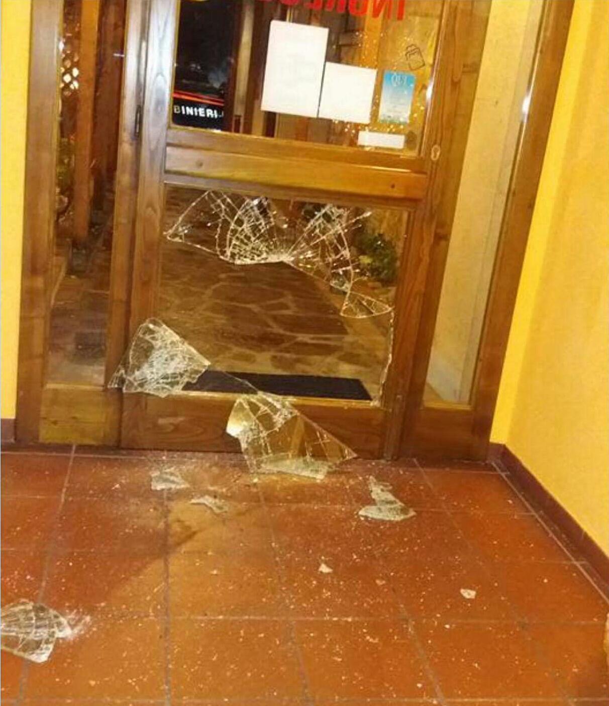 La porta di ingresso spaccata con un masso