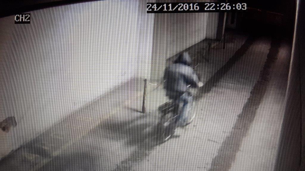 Il ladro mentre si allontana pedalando dal garage di piazza Mazzini