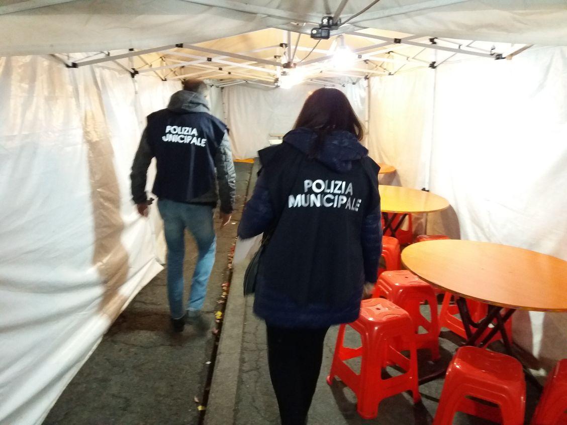 Controlli dei vigili anti-contraffazione in un esercizio di commercio ambulante
