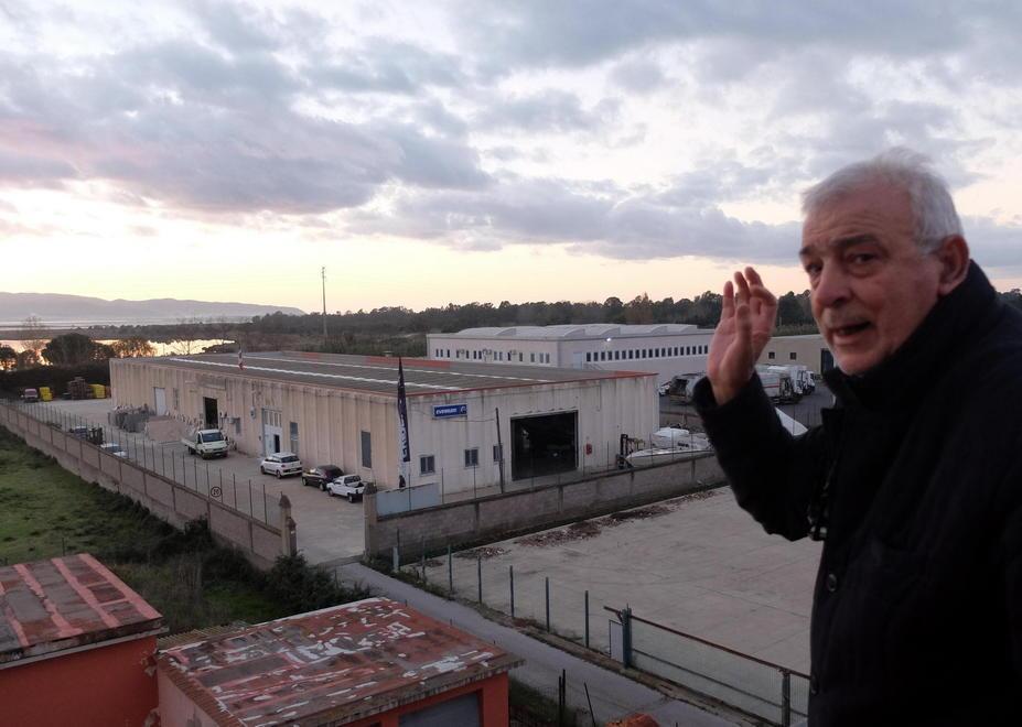 Marcello Galeazzi ritratto sul tetto della sua rivendita di mobili a Campolungo (Orbetello) mostra la zona in cui il tracciato autostradale potrebbe spazzare via le attività esistenti (foto Enzo Russo)