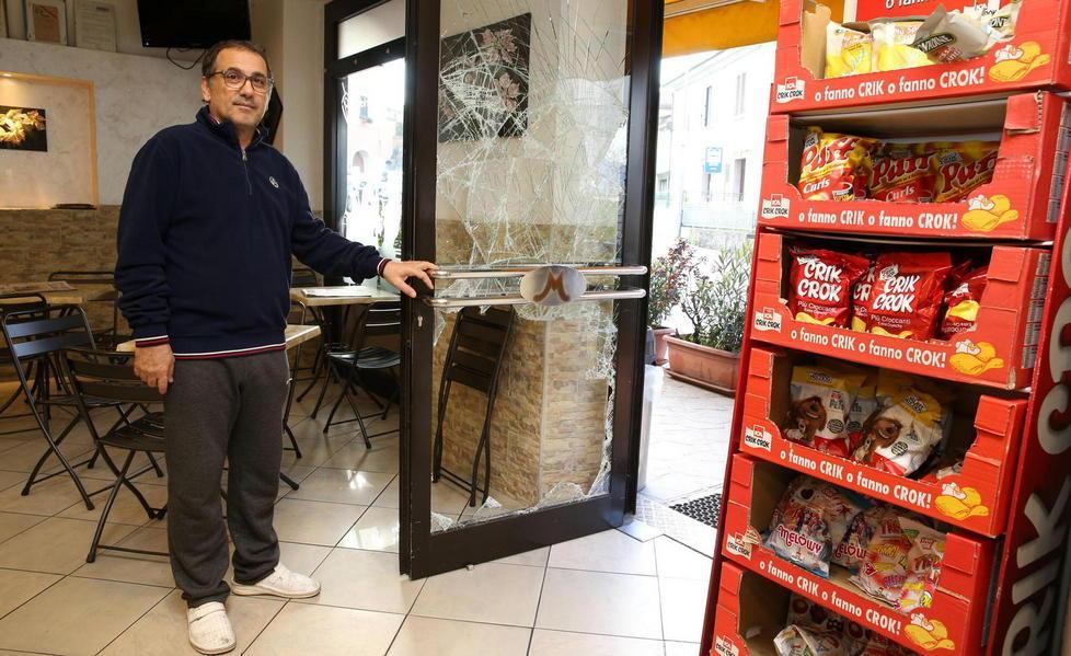 Roberto Agostino mostra la vetrata del bar spaccata dai ladri (foto Nucci)