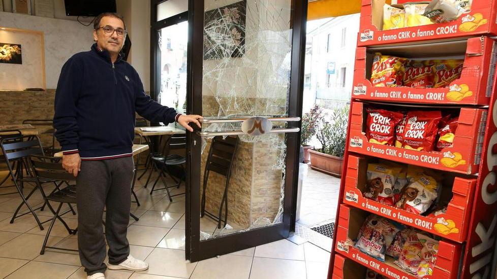 Roberto Agostino mostra la vetrata del bar spaccata dai ladri (foto Nucci)