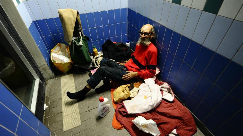 Un senzatetto che dorme dentro la stazione