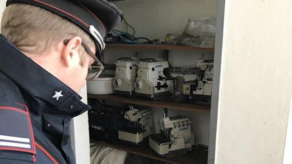 Un carabiniere controlla le macchine da cucire recuperate
