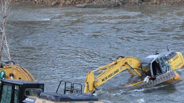 Finisce in Arno con l’escavatore