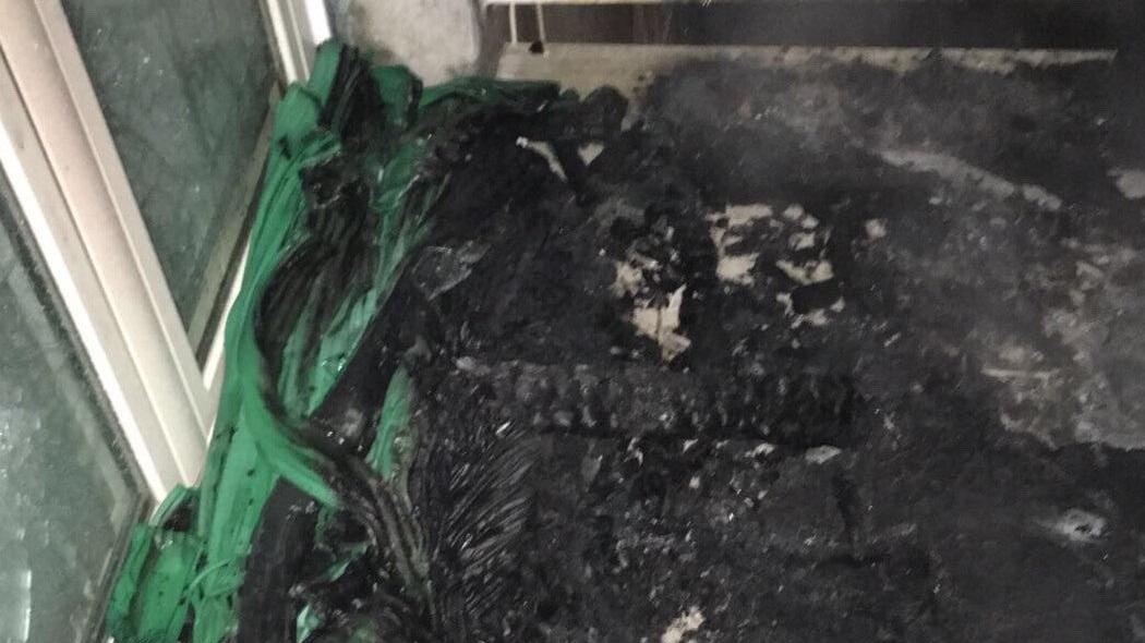 Cosa rimane del divano bruciato sul terrazzo di un'abitazione