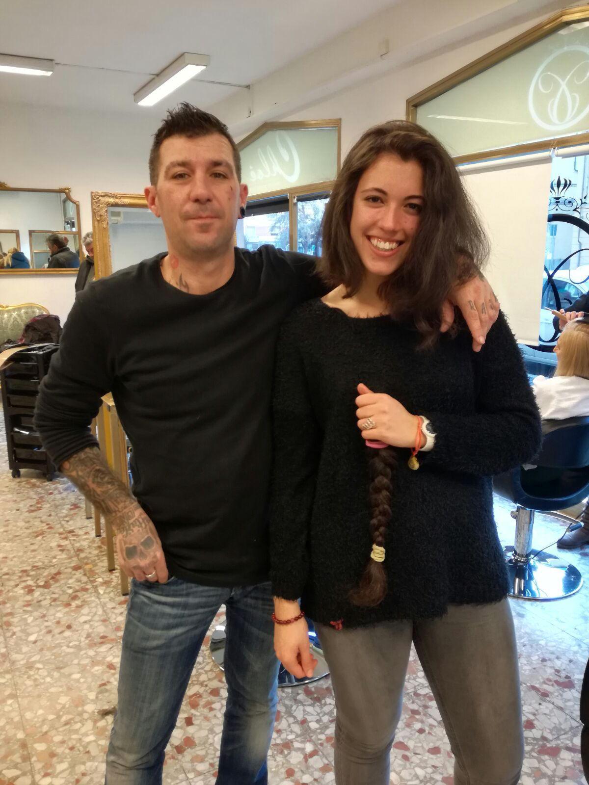 Michela insieme al parrucchiere esibisce la treccia appena tagliata