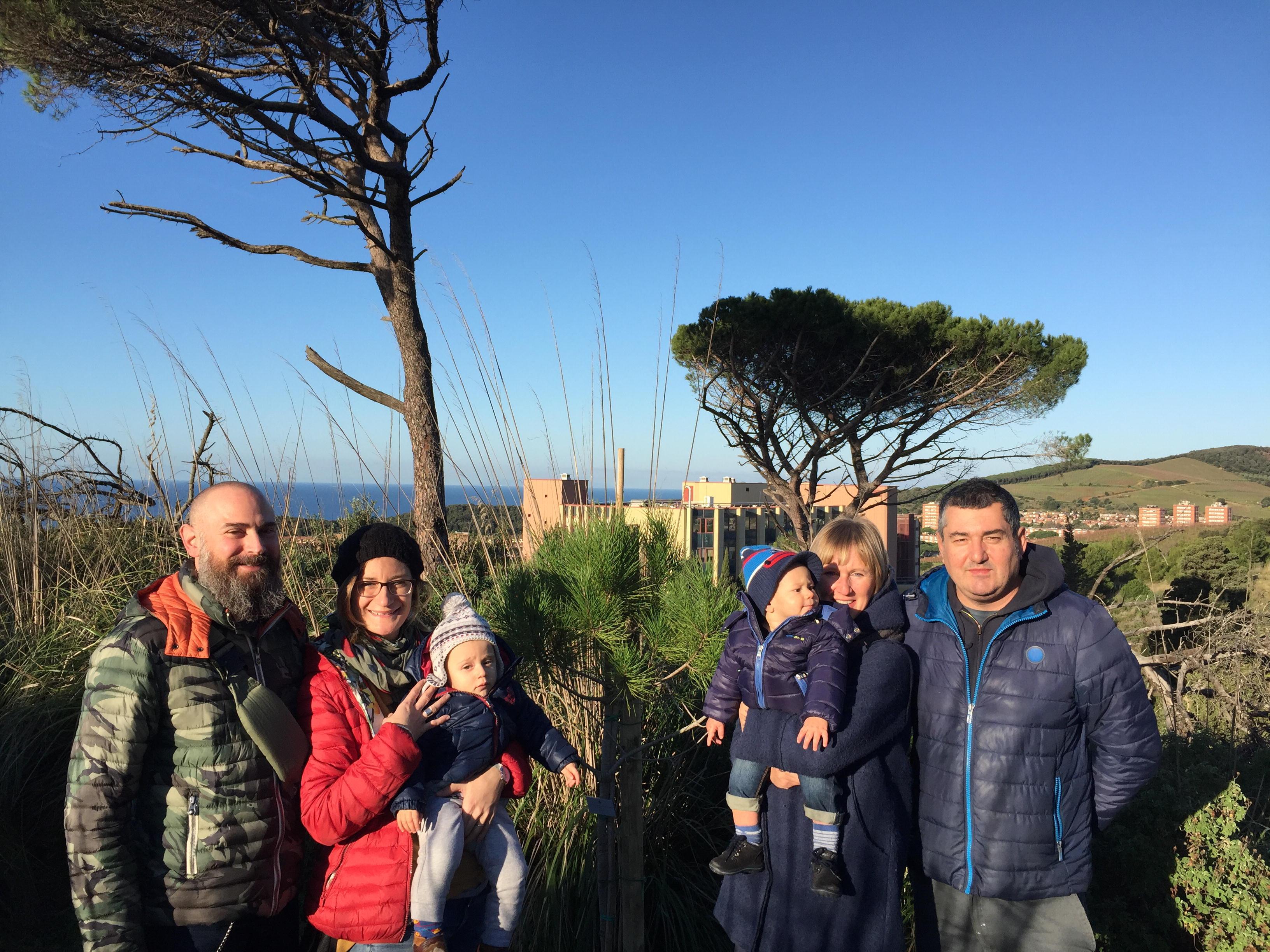 Famiglie e bambini davanti ai pini appena piantati
