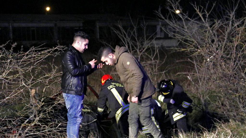 L'auto fuori strada e i vigili del fuoco al lavoro (Marzi/Pentafoto)
