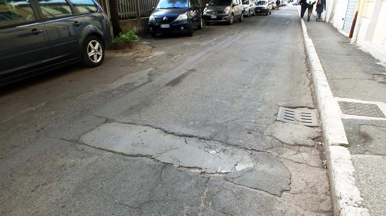 Via Roma, strada sconnessa, piena di buche (foto Paolo Barlettani)
