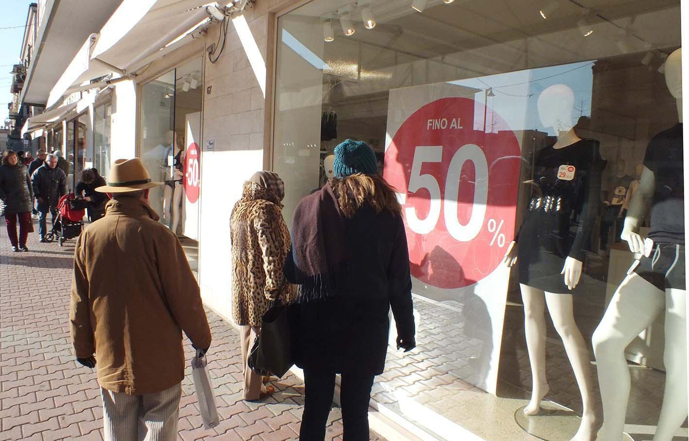 Persone davanti alle vetrine per i saldi invernali