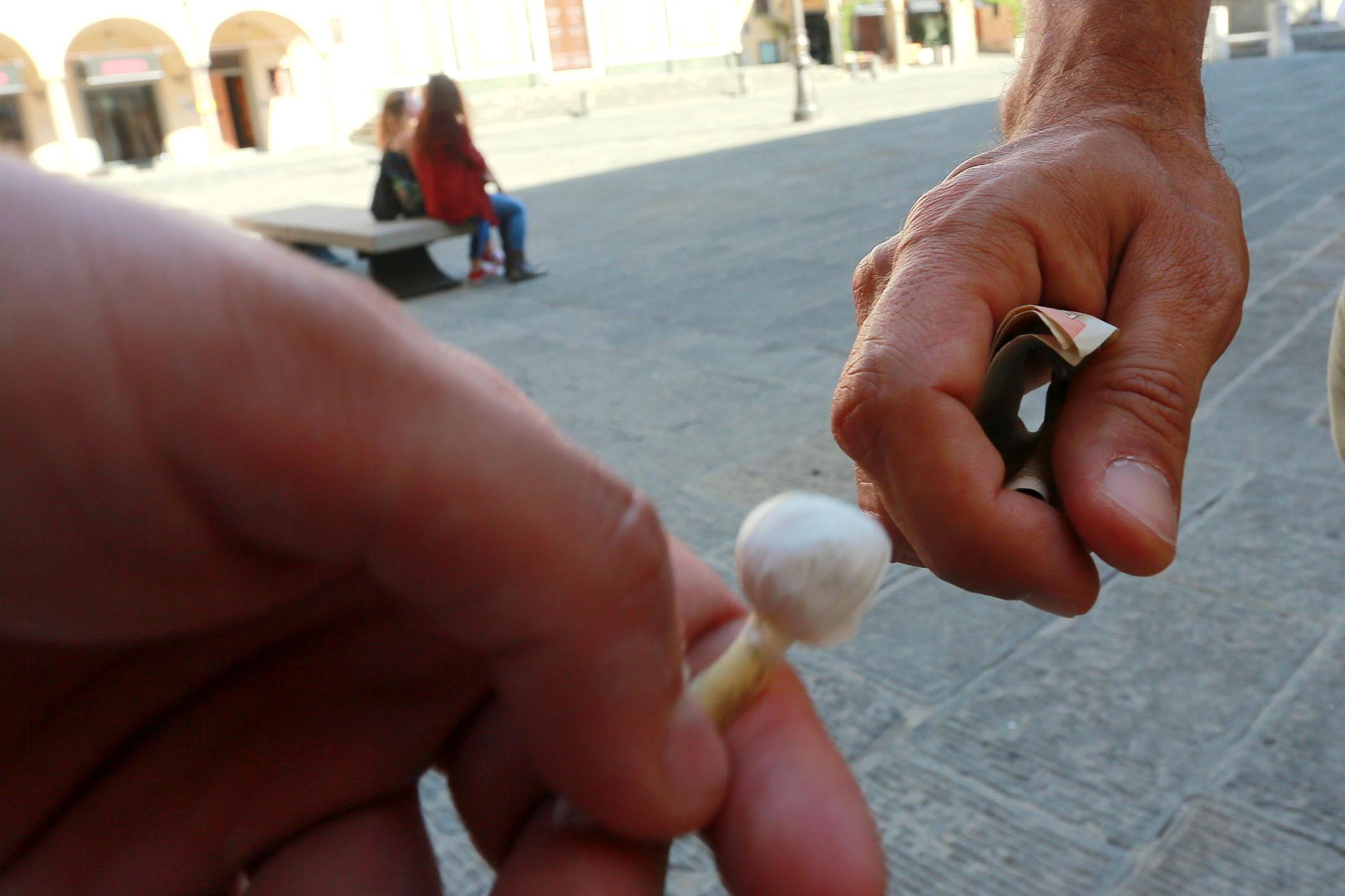 Uno spacciatore mentre sta vendendo una dose di droga (foto di archivio)