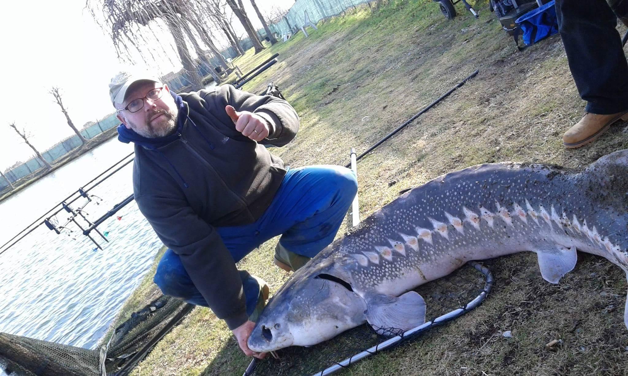 Simone Pardini con lo storione di 100 kg pescato nel lago di Mollungo alla Ferruccia di Quarrata