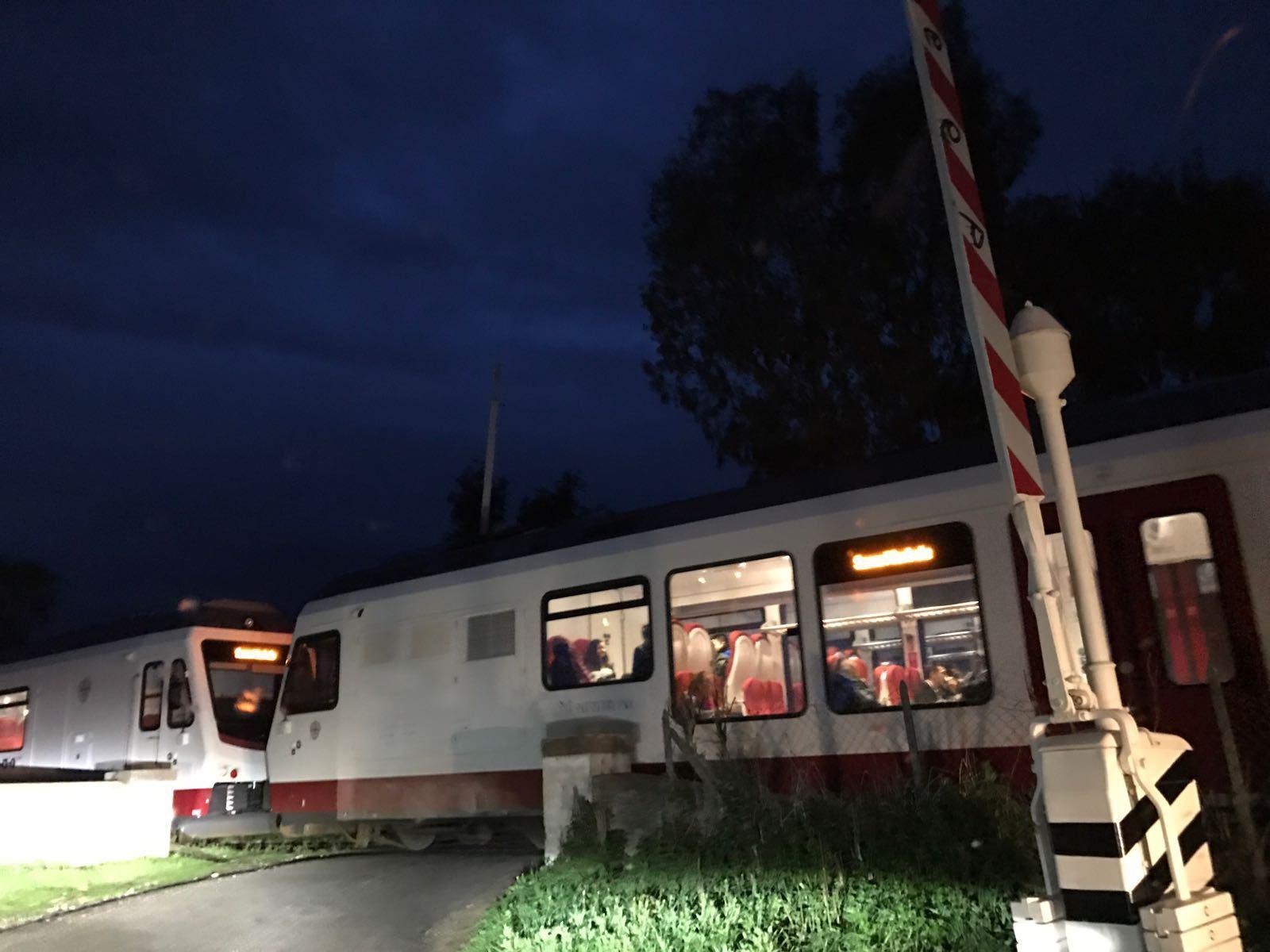 Il treno che transita con il passaggio a livello aperto