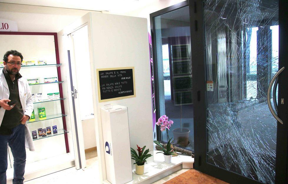 Uno dei farmacisti accanto alla vetrata spaccata dai ladri entrati in azione domenica sera