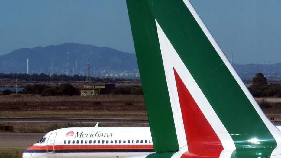 La coda di un aereo di Alitalia e, sullo sfondo, un aereo di Meridiana