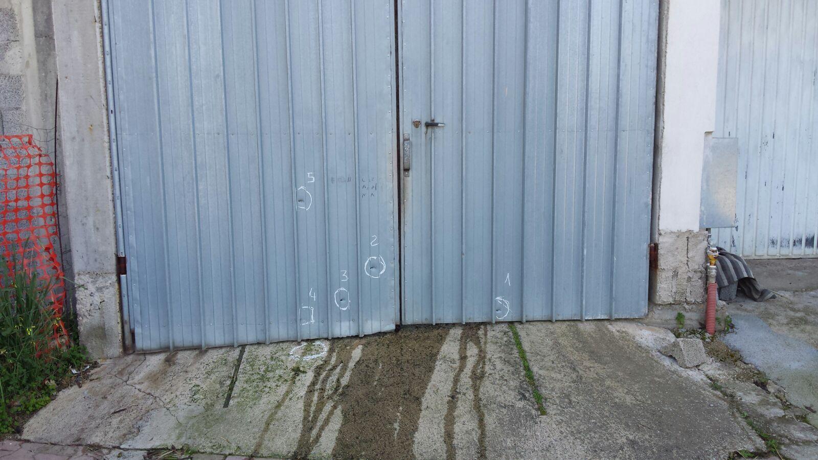 I fori dei pallettoni sulla serranda del garage