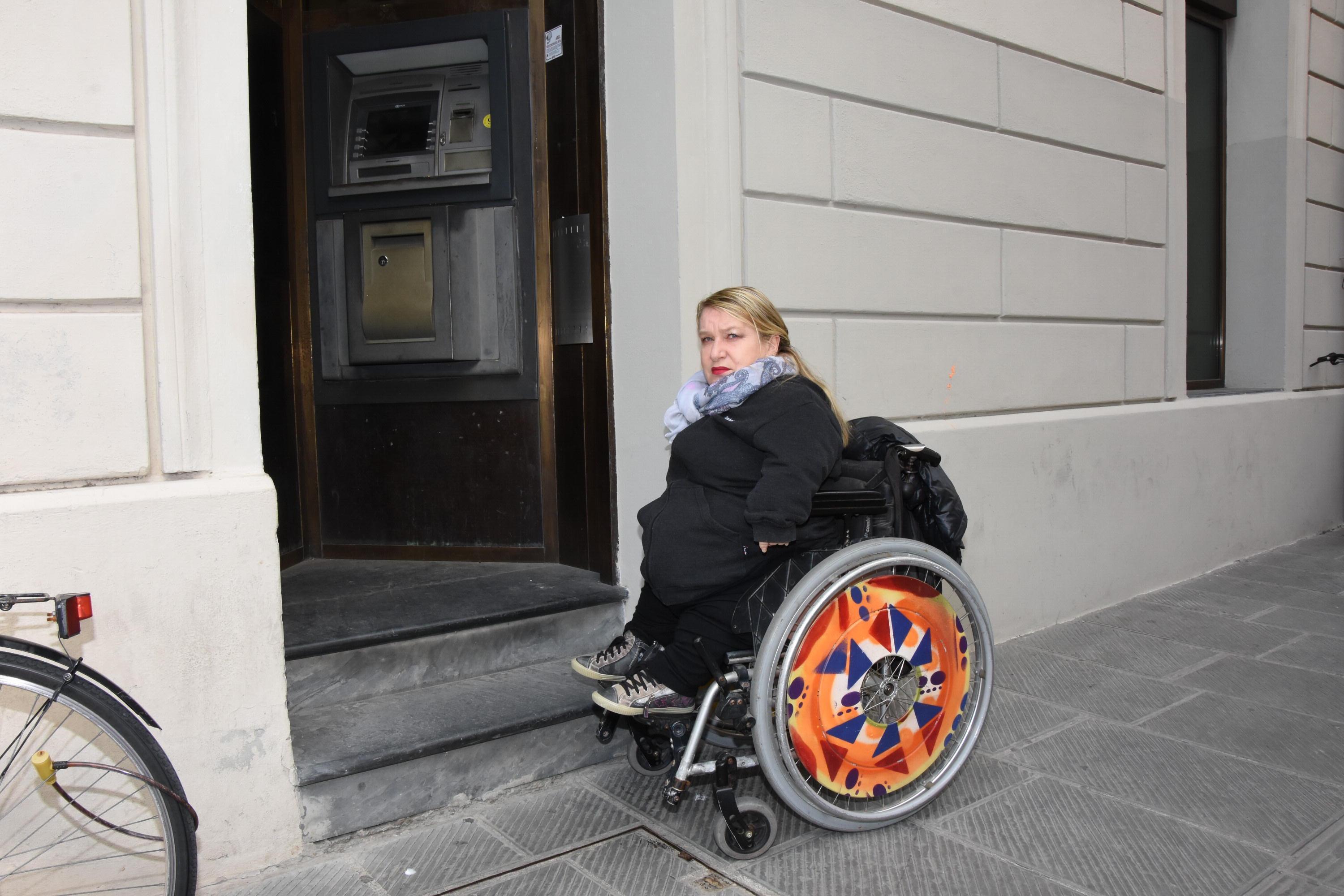 Lorella Ronconi davanti al bancomat inaccessibile a chi è in carrozzella (foto Agenzia Bf)