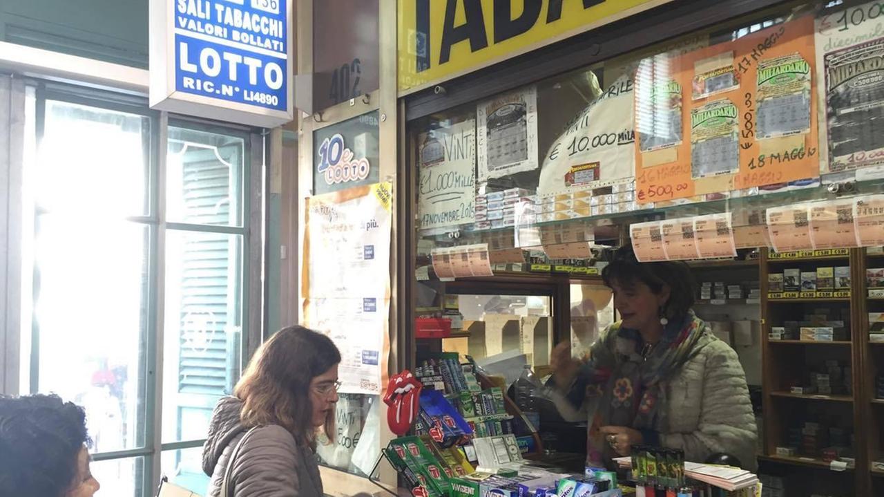 La tabaccaia Cecilia Lombardo serve clienti nel suo chiosco al mercato