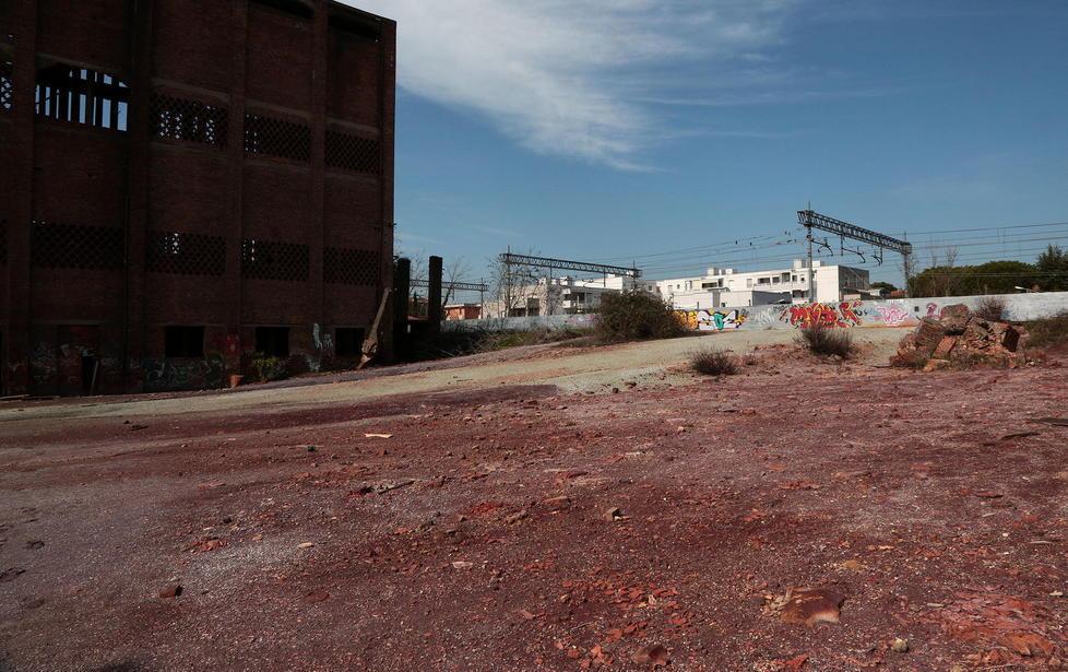 Acqua arancione nel rio che scorre tra case e parco 