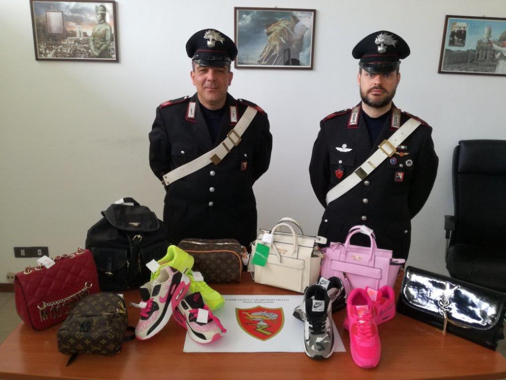 I carabinieri col materiale sequestrato nel negozio di via Filzi
