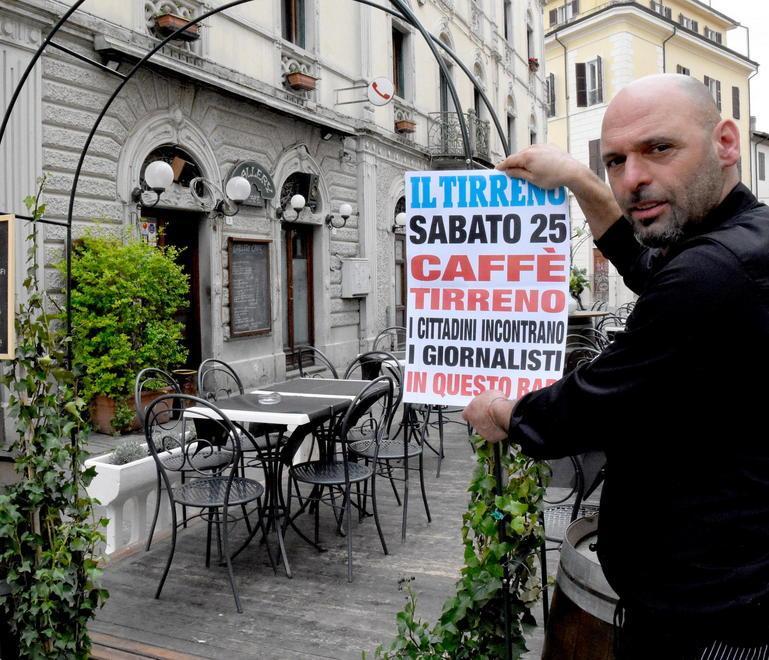 Mauro Sbrana, titolare del Gallery Caffè, mostra la locandina di Caffè Tirreno, l'appuntamento dei giornalisti della redazione grossetana del Tirreno con i cittadini (foto Agenzia Bf)