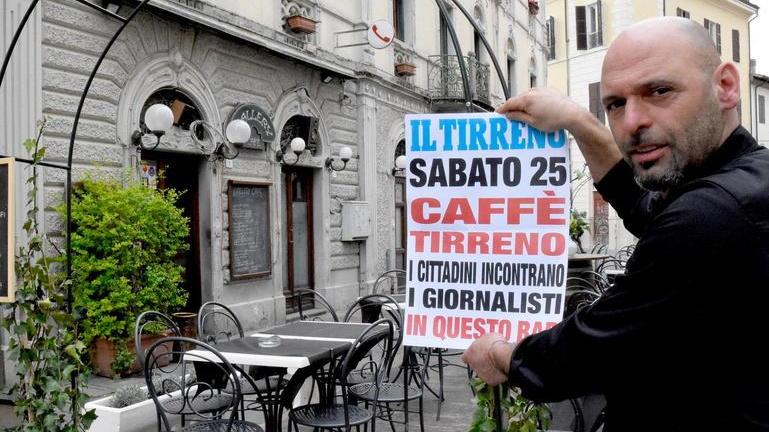 Mauro Sbrana, titolare del Gallery Caffè, mostra la locandina di Caffè Tirreno, l'appuntamento dei giornalisti della redazione grossetana del Tirreno con i cittadini (foto Agenzia Bf)