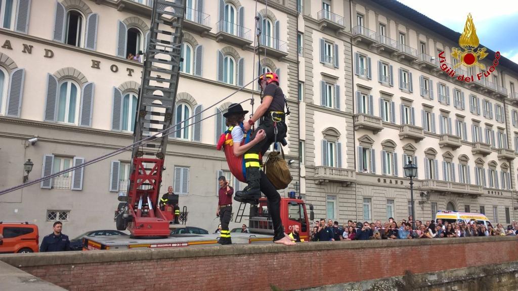 Il vigile del fuoco mentre porta in salvo il pescatore rimasto bloccato nel fiume