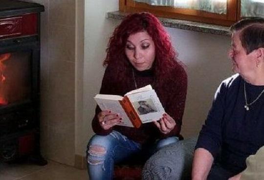 Stefania Corona legge un libro a un'anziana di Ollolai