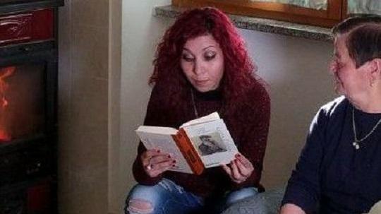 Stefania Corona legge un libro a un'anziana di Ollolai